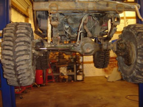 1992 Ford Bronco - Vehicle's undercarriage and suspension components are visible while it's lifted for service.