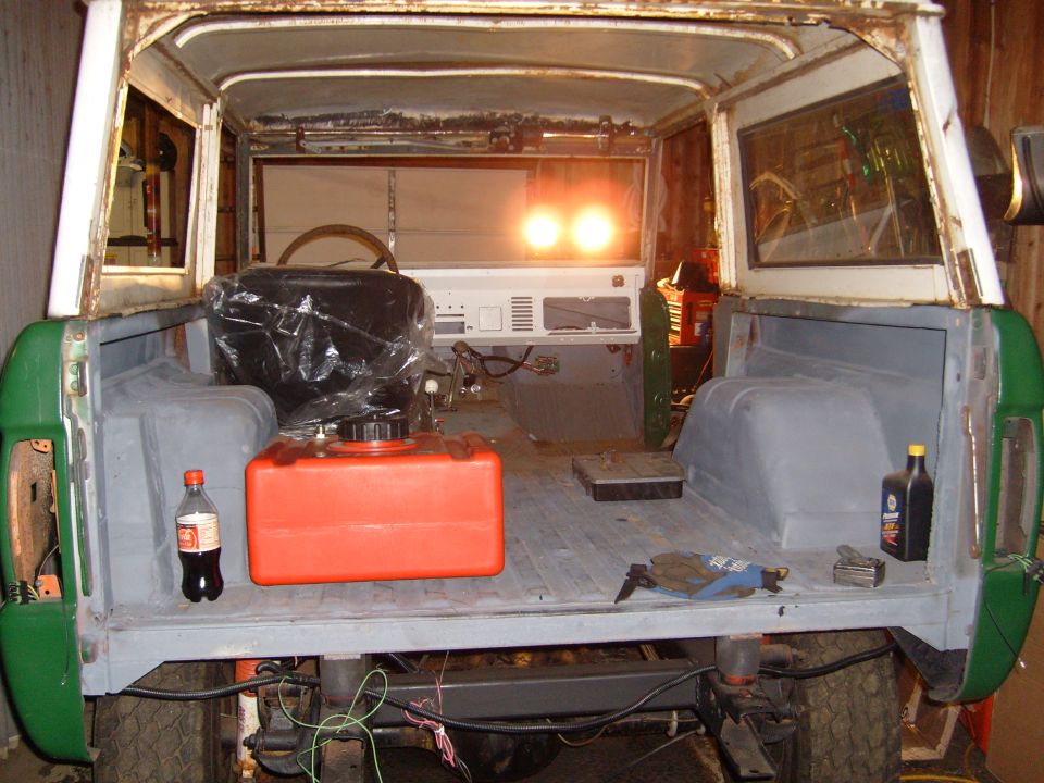 1974 Ford Bronco interior with orange fuel can and plastic-wrapped seat