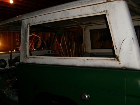 1974 Ford Bronco - The interior of a classic Ford Bronco shows its age with missing window frames and a worn steering wheel.