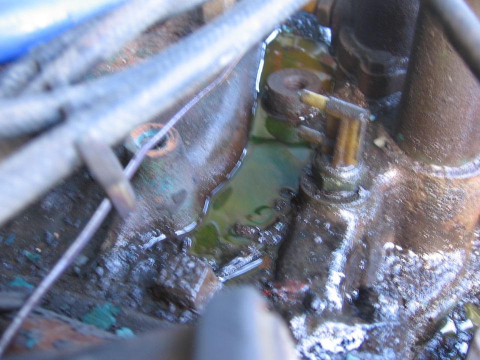 Close-up of engine component with green fluid pooling around it