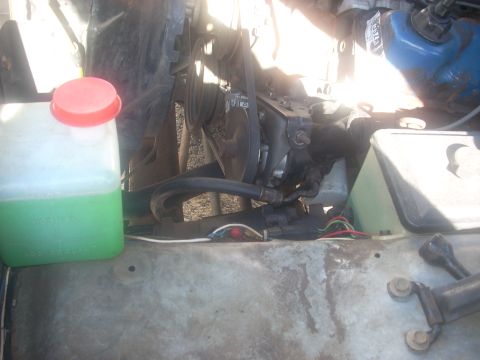 1992 Ford Bronco - Close-up view of an engine bay, showing a coolant reservoir and various engine components.