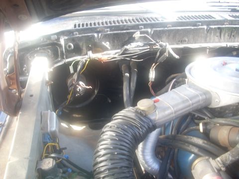 1992 Ford Bronco - The engine bay of a vehicle is shown, with various components and wiring exposed.