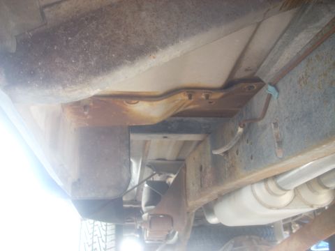 1992 Ford Bronco - A view of the undercarriage reveals the vehicle's frame and exhaust system, with visible signs of wear and tear.