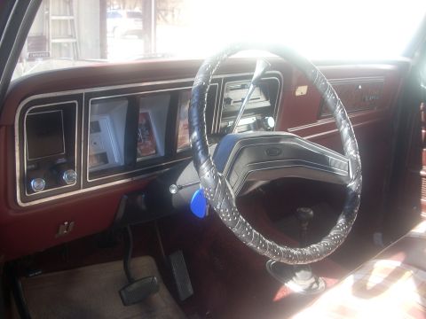 1992 Ford Bronco - The interior of a vintage vehicle shows a dashboard with a steering wheel and various controls, along with a watermark at the bottom.