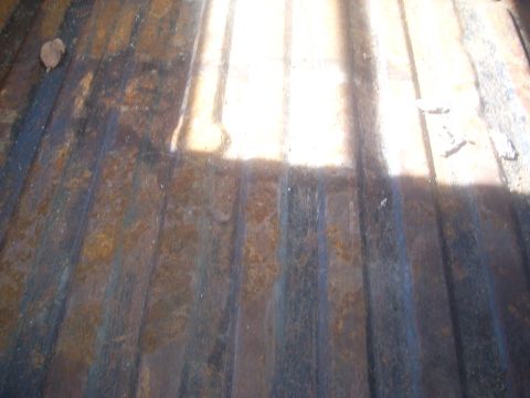 1992 Ford Bronco - The ribbed floor of a truck bed shows significant rust and wear.
