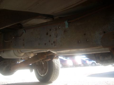 1992 Ford Bronco - A view of the undercarriage of a vehicle, showing the frame and drivetrain components.