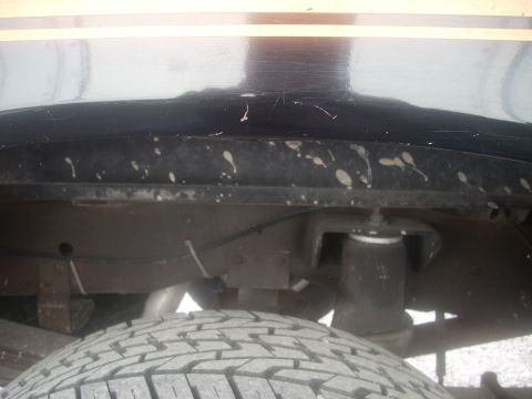1992 Ford Bronco - Close-up view of the rear suspension and tire, showing the undercarriage of the vehicle.