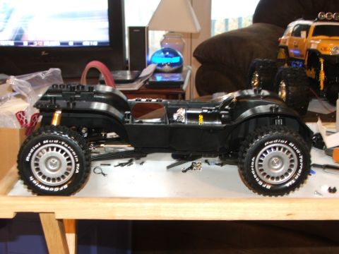 1996 Ford Bronco - A black remote control car chassis sits on a table, with another yellow RC vehicle visible in the background.