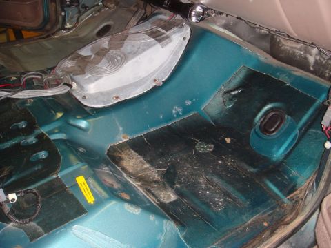 1996 Ford Bronco - The interior floor of the vehicle shows exposed metal and some rust, with wiring visible.