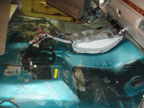 1996 Ford Bronco - The interior floor of a 1996 Ford Bronco shows exposed wiring and signs of rust damage.