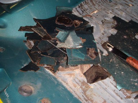 1996 Ford Bronco - Peeling undercoating reveals rust on the interior floor of a 1996 Ford Bronco.