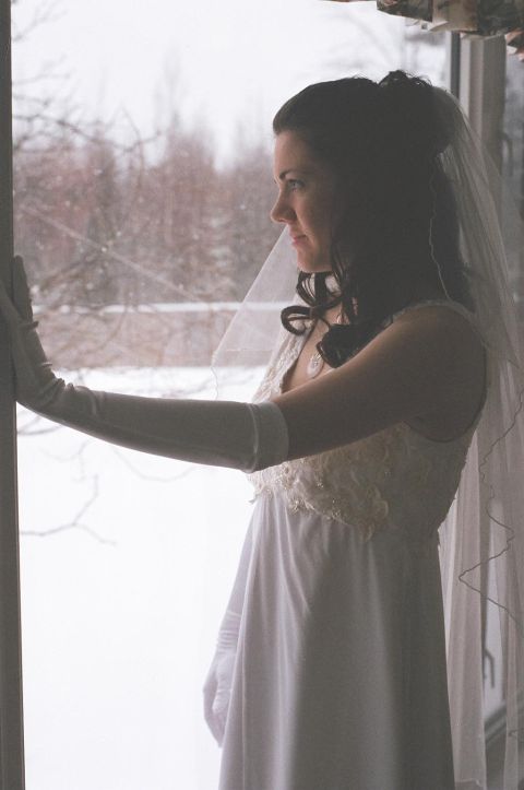 1984 Ford Bronco - A bride in a wedding dress gazes out a window on a snowy day.