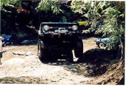 1976 Ford Bronco - This heavily modified vehicle navigates a challenging off-road course with other vehicles nearby.