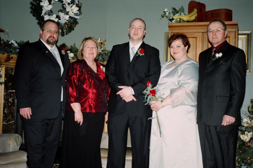 Five people in formal attire posing for a photo indoors