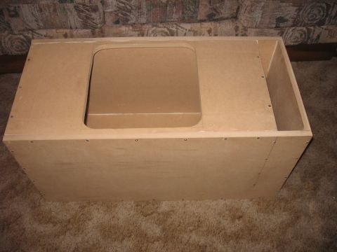 1992 Ford Crown Victoria - This image shows an unfinished wooden subwoofer box, likely a custom build, with a central cutout on its top surface.