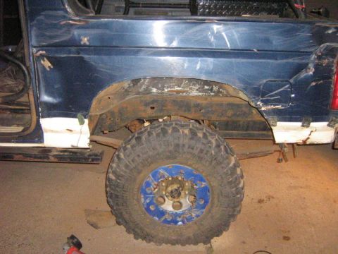 1986 Ford Bronco - Rear side view of a modified 1986 Ford Bronco, with visible rust on the fender and body panels.