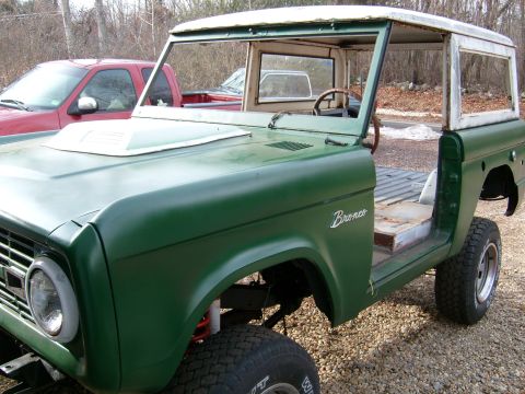 1974 Ford Bronco - 1974 Ford Bronco body in green, undergoing restoration. Another vehicle is visible behind it.