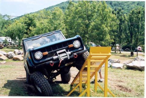 1976 Ford Bronco - A blue 1976 Ford Bronco is positioned on a dirt ramp, ready for an off-road challenge.
