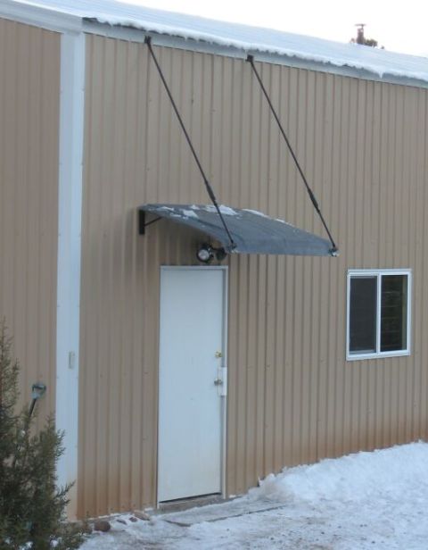 1986 Ford Ranger - Exterior view of a building with tan corrugated siding, a white door, and a small window, with snow on the ground.