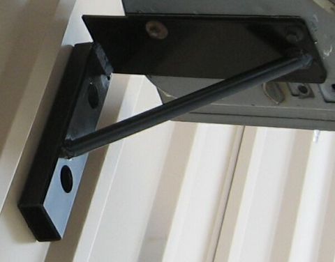 1986 Ford Ranger - A metal bracket is bolted to the underside of a vehicle, likely for accessory mounting.