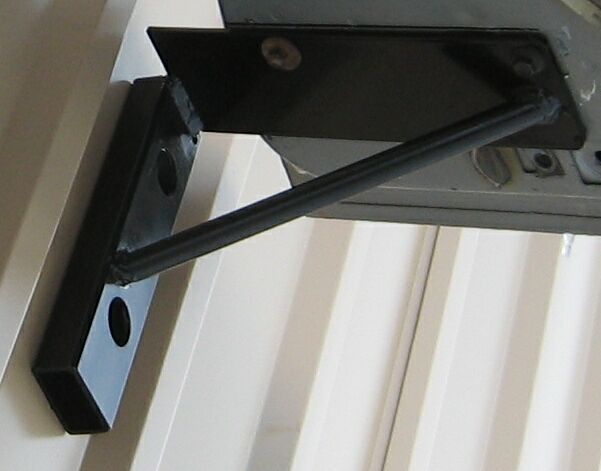 Close-up of a black metal bracket attached to a vehicle's frame