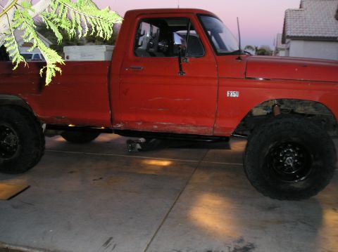 1986 Toyota Hilux - This red Ford F-250 pickup truck is shown from the side, large tires and a toolbox in the bed.