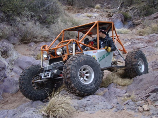 buggy with roll cage and big tires climbing rocks
