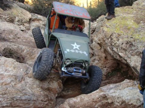 1987 Suzuki Samurai - This custom off-road buggy navigates a rocky trail, displaying "M-O-N-G-O" on its hood.