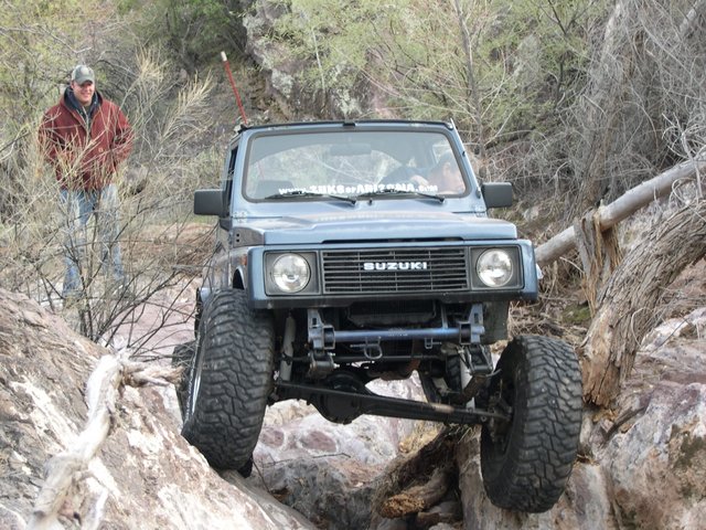 Blue 1987 Suzuki Samurai navigating rocky terrain