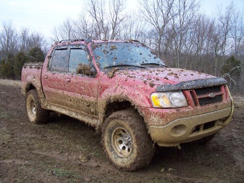2002 Ford Sport Trac - This red 2002 Ford Sport Trac is heavily covered in mud after off-roading.