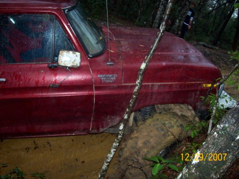 1978 Ford Bronco - This 1978 Ford Bronco appears to be stuck deep in the mud, with trees and foliage surrounding it.