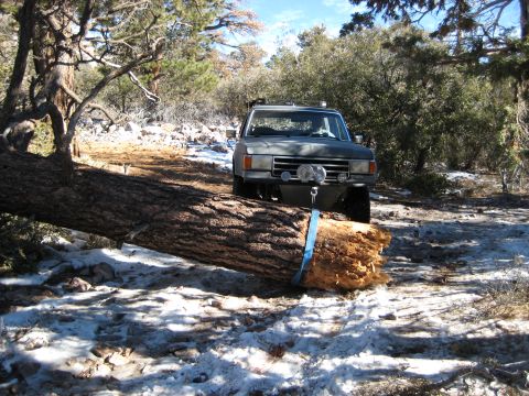 1996 Ford Bronco - Ford Bronco winching a large fallen tree off a snowy mountain trail.