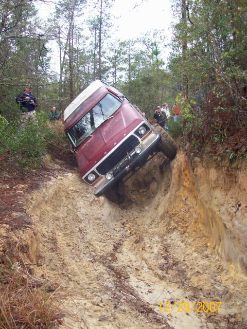 1978 Ford Bronco - Ford Bronco navigating a challenging muddy terrain, tilted at a steep angle.