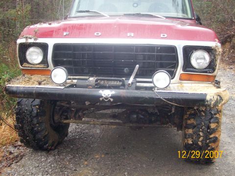 1978 Ford Bronco - Mud-covered 1978 Ford Bronco front view with auxiliary lights and a winch.