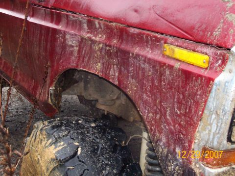 1978 Ford Bronco - Close-up of a muddy vehicle's fender and tire, with a date stamp visible in the corner.