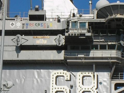 1989 Ford F-250 - The superstructure of the USS Nimitz aircraft carrier is visible, showing deck markings and various bridge structures.
