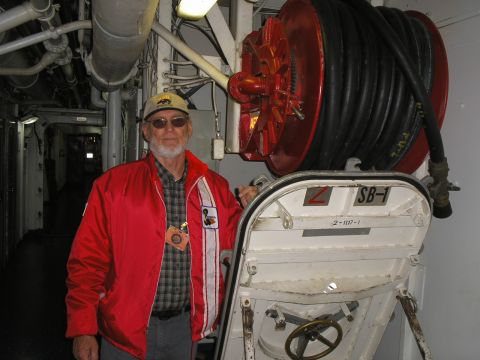 1989 Ford F-250 - A man poses for a photo inside a ship's corridor, next to a fire hose reel and a watertight door.
