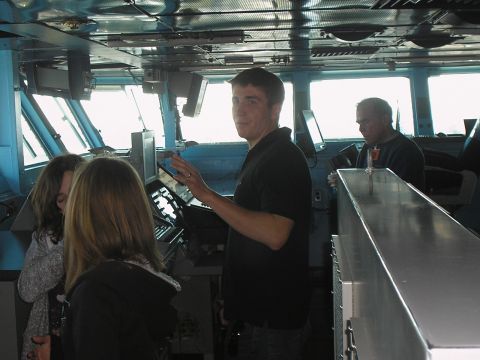 1989 Ford F-250 - People gather inside a ship's bridge, with windows showing the outside.