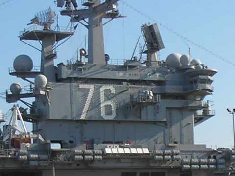 1989 Ford F-250 - The USS America (CV-66) aircraft carrier, identified by the number 76, is seen docked at port.