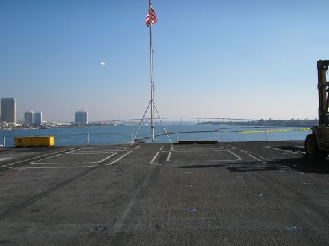 1989 Ford F-250 - View from a flight deck shows a forklift, city skyline, and a bridge across the water.