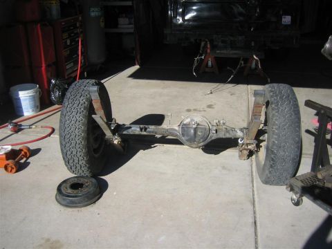 1987 Suzuki Samurai - The rear axle assembly of a vehicle is shown, detached and resting on the floor of a garage.