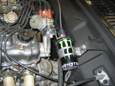 1987 Suzuki Samurai - Close-up of an engine bay, a Monster Energy branded ignition coil pack and distributor.