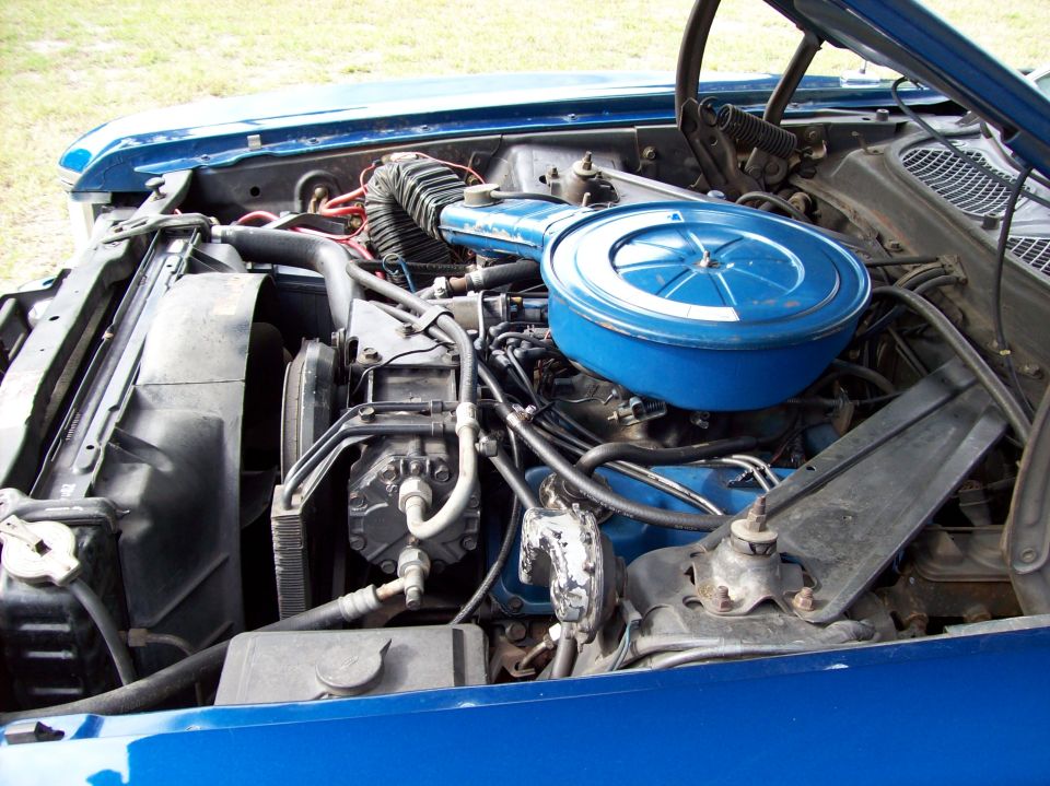 Blue engine bay with a blue air cleaner assembly, fan, and hoses visible