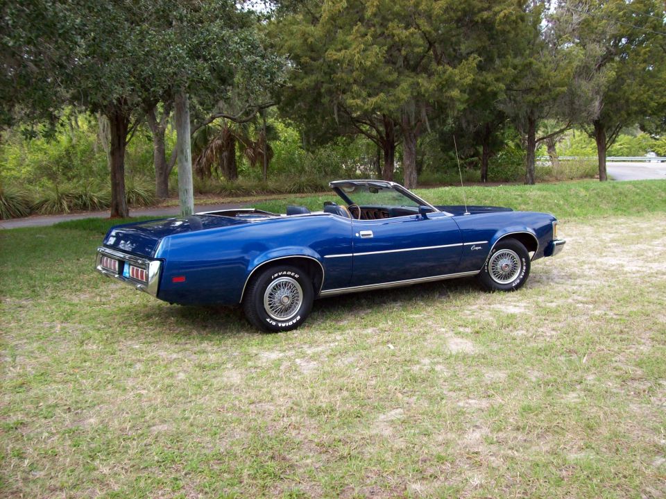 1973 Mercury Cougar convertible parked on grass with trees in background