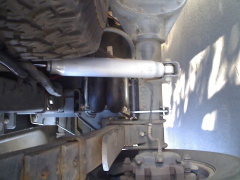 1971 Ford Bronco - Close-up of vehicle's rear suspension system, showing air helper springs and shock absorber.