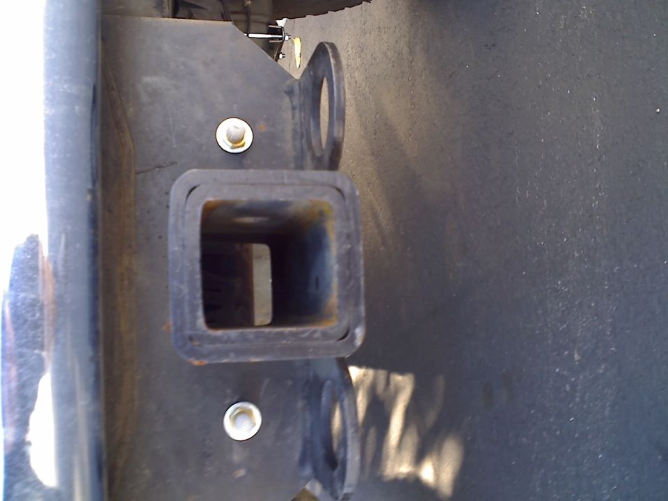 Close-up of a trailer hitch receiver on a vehicle frame