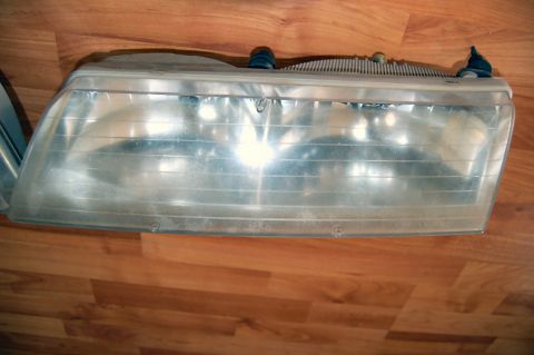 1985 Mercury Grand Marquis - A single headlight assembly is shown, likely for restoration, against a wood-grain background.