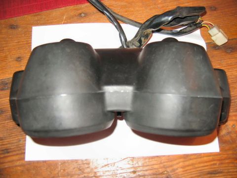 1985 Ford LTD Crown Victoria - A black plastic motorcycle instrument cluster with wiring is shown on a wooden surface.