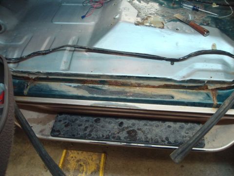 1996 Ford Bronco - Rust and exposed wiring are visible on the interior floor of a vehicle, indicating repair work is needed.