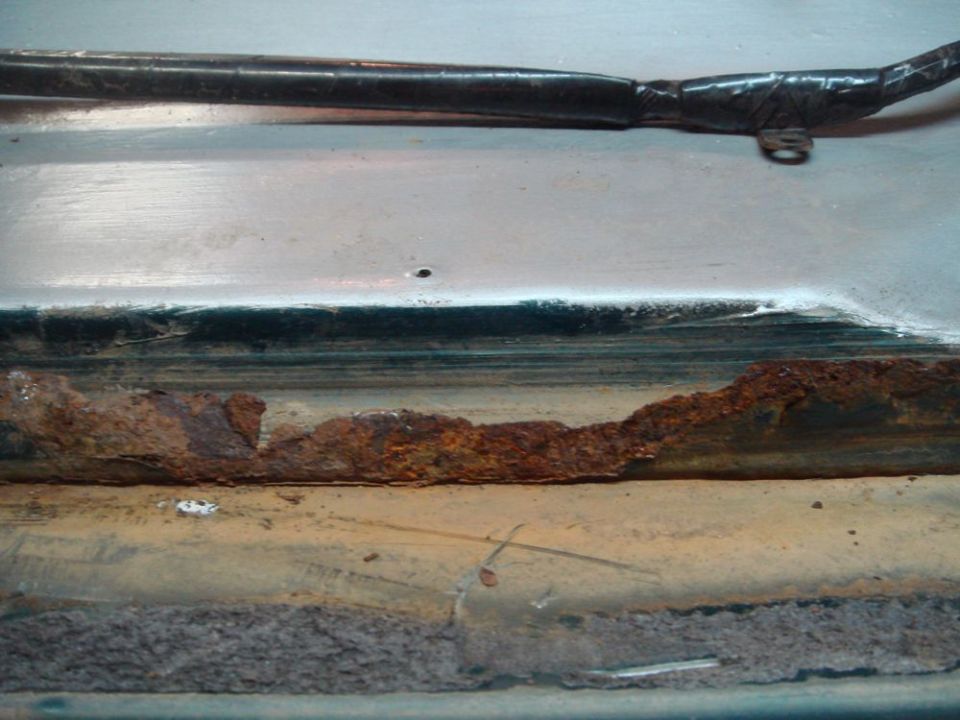 Rusted door jam with visible corrosion and damage